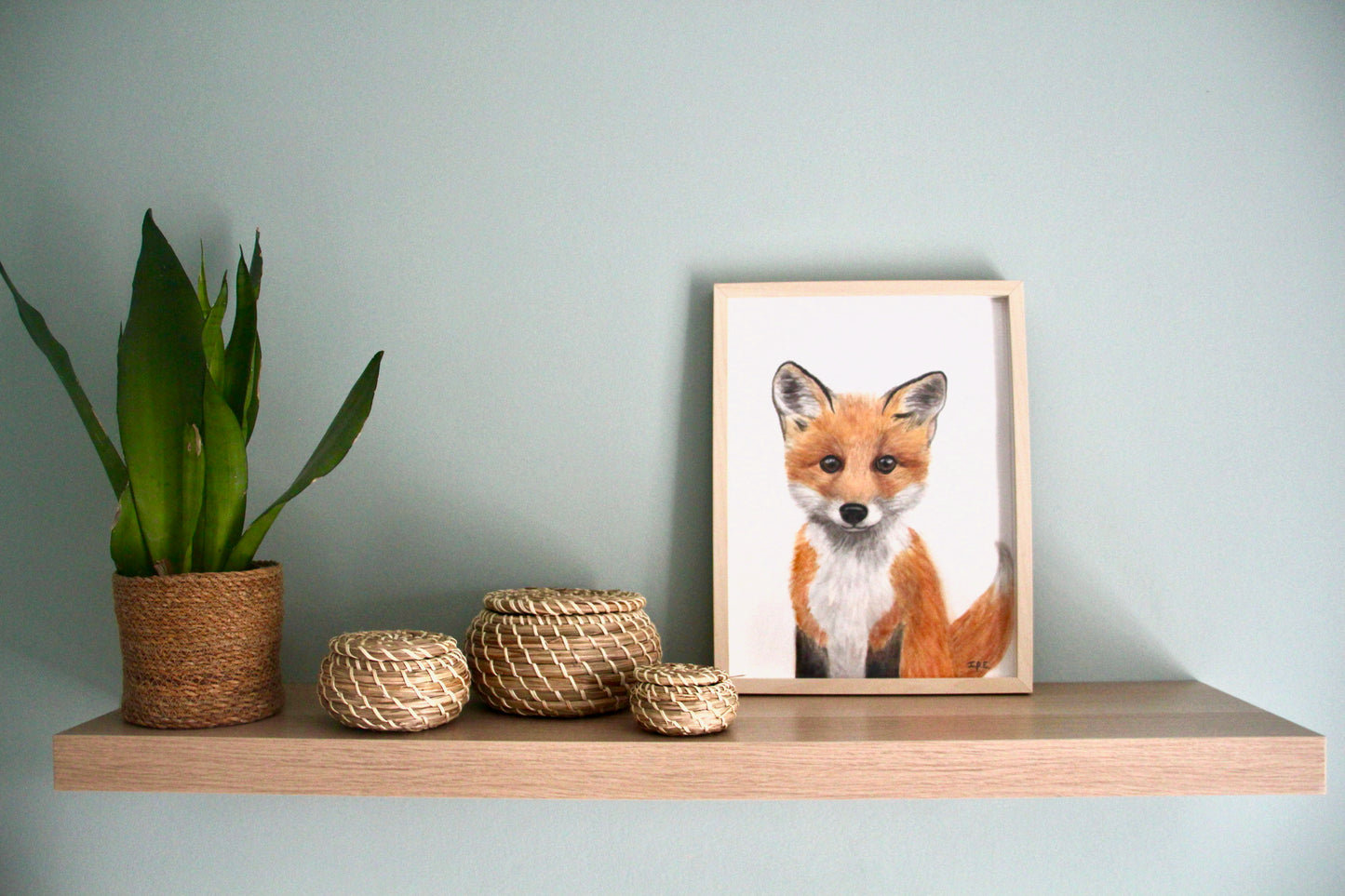 Fox print framed on a shelf with decor