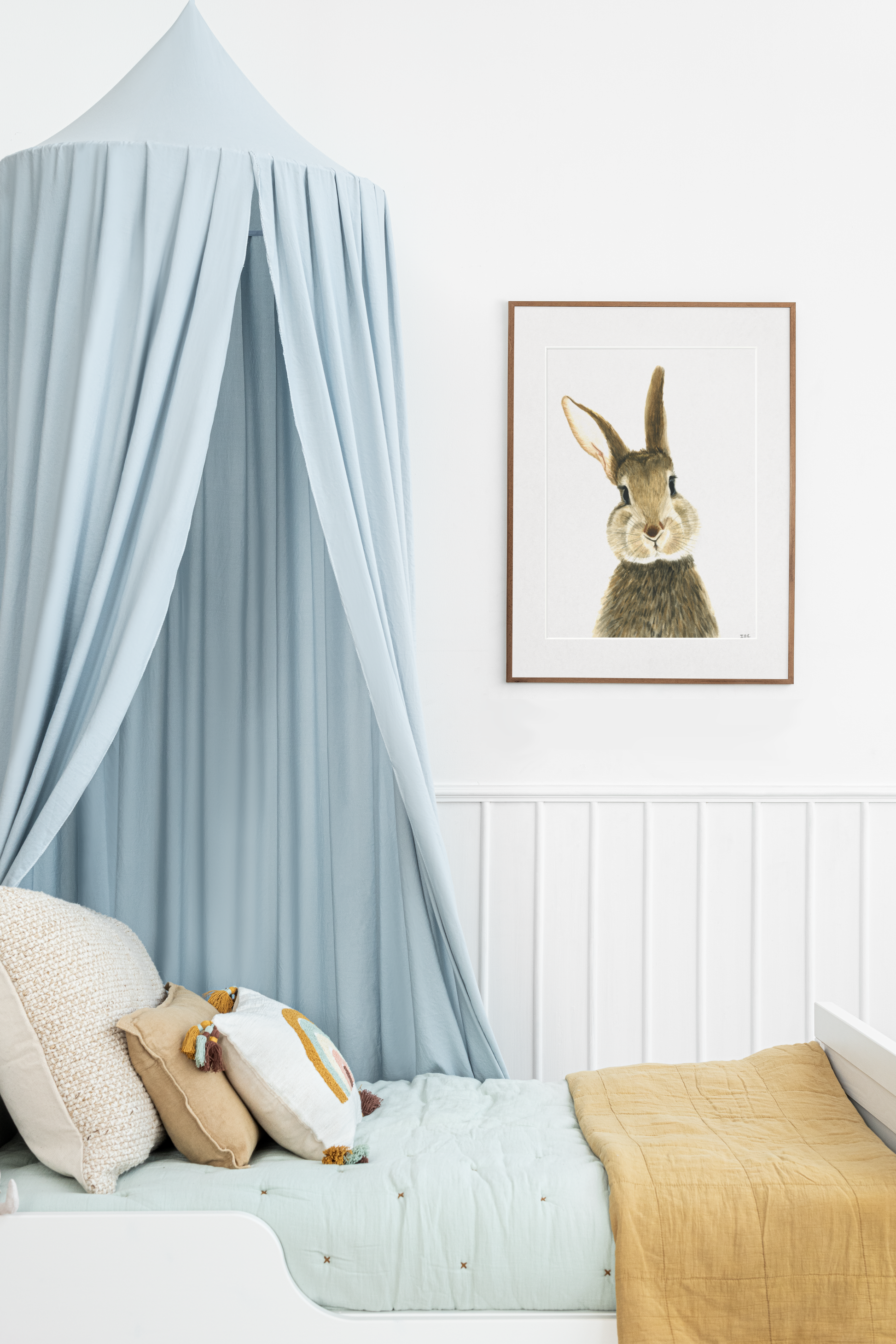 Framed bunny rabbit above children's bed in kidsroom