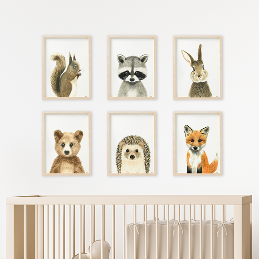 Set of 6 woodland nursery prints above baby crib: squirrel, racoon, rabbit, bear, hedgehog and fox
