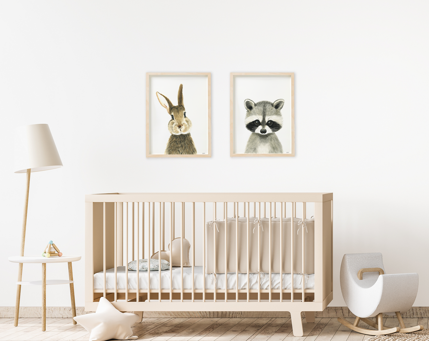 Set of 2 animal wall art prints above a baby crib in a nursery: rabbit and racoon